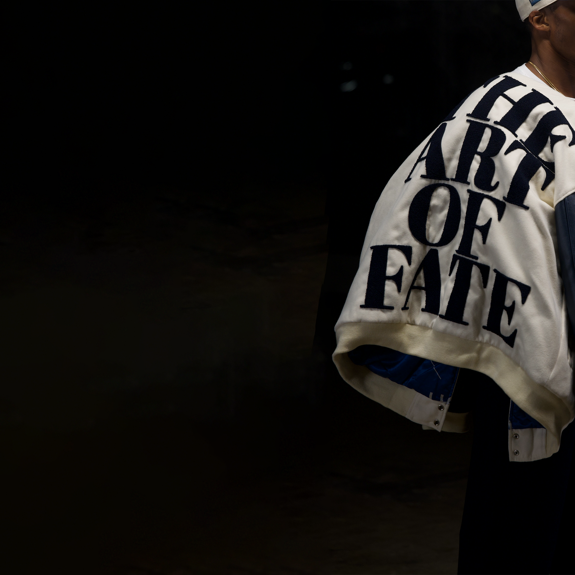 Person wearing a jacket with 'The Art of Fate' text on a dark background